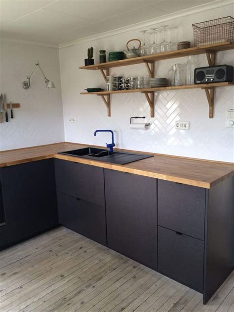 Classic yet modern, this timeless kitchen sets off its elegant black cabinets and bold floor tile with a warm wood island. 25 Ideas To Renovate Your Kitchen On A Budget - DigsDigs