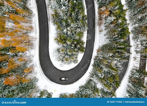 Aerial View Of Car On Winding Road In Snowy Winter Forest Stock Photo