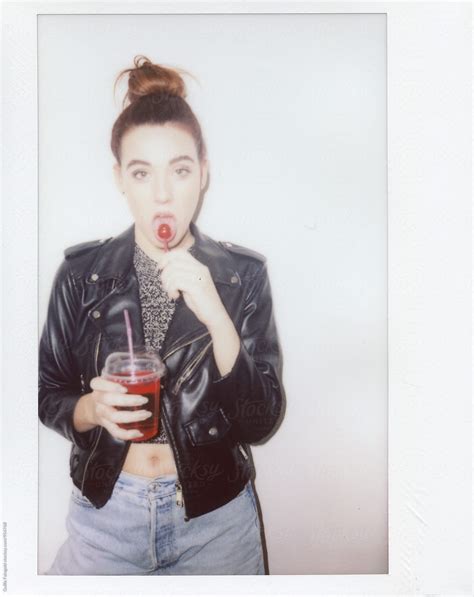 Young Woman Eating Chupa Chups And Holding Drink By Stocksy