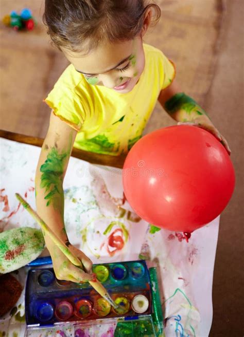 Bringing Her Creativity To Life An Adorable Little Girl Making A Mess