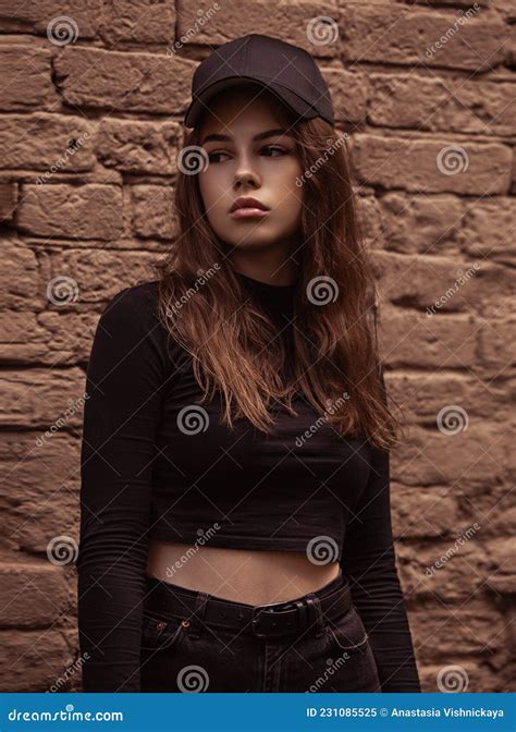 Sad Emotional Young Woman Looking Unhappy Near The Red Brick Wall On