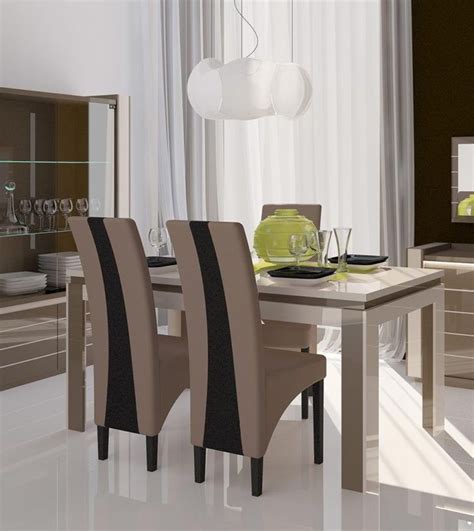 a dining room table with four chairs and a glass vase on the table in