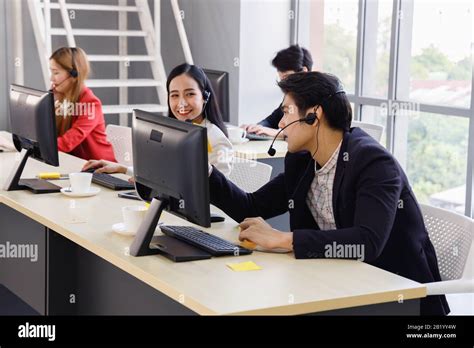 Asian Call Center Employees Working Together At Office Concept For