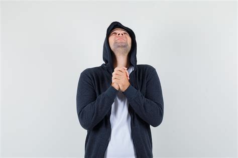 Free Photo Young Male Clasping Hands In Praying Gesture In Jacket T