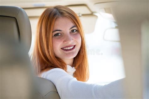 Young Redhead Woman Driver Driving A Car Smiling Happily Stock Image