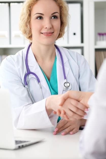 Premium Photo Happy Blonde Female Doctor Shaking Hands With Patient