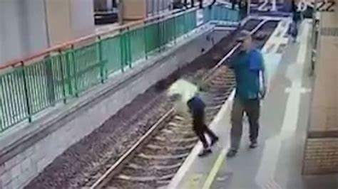 Shocking moment man pushes woman onto train tracks in Hong Kong Voie ferrée Hong kong