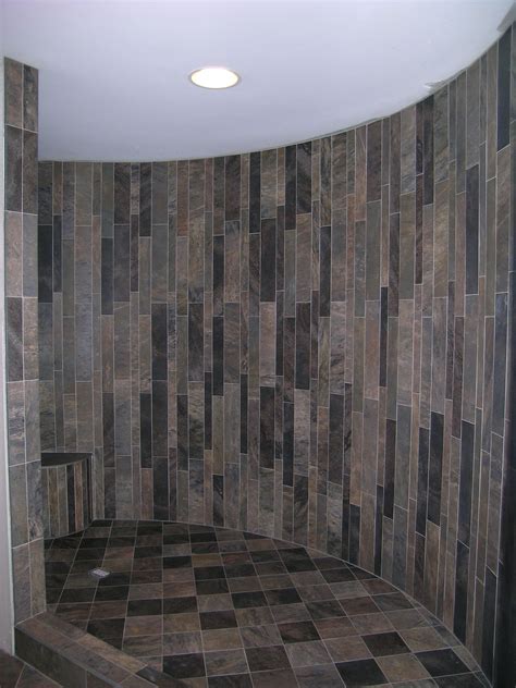 A Bathroom With Tiled Walls And Flooring In The Shower Area Along With