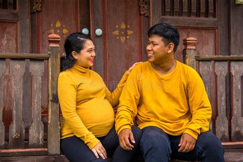 Indonesian Pregnant Wife Sits With Her Husband Outside Their