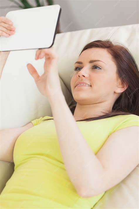 premium photo cheerful teen lying on a sofa using a tablet pc