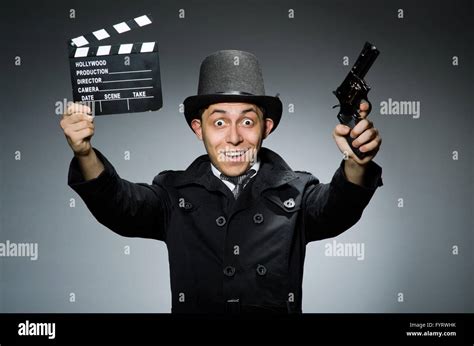 Young Man With Weapon And Clapboard Against Gray Stock Photo Alamy