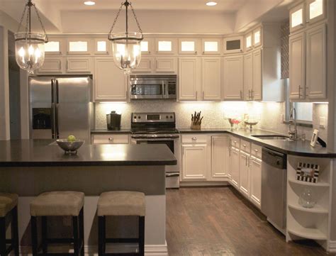 White and brown kitchen features white upper cabinets and brown distressed lower cabinets paired with fantasy brown granite countertops and a linear marble tiled backsplash. Kitchen Pendant Lightning as Contemporary Home Decor - Amaza Design