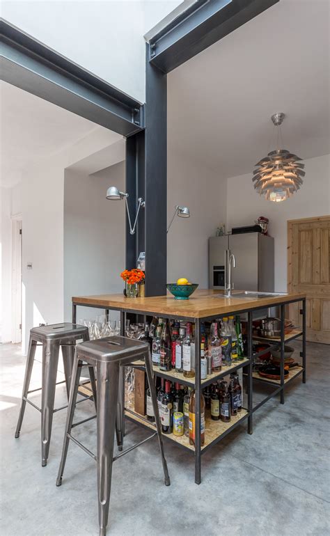 Island kitchen with raised cabinetry on each end. Modern style industrial kitchen | open shelving | exposed ...