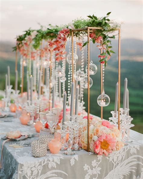 A Long Table With Candles And Flowers On It Is Set Up For An Outdoor