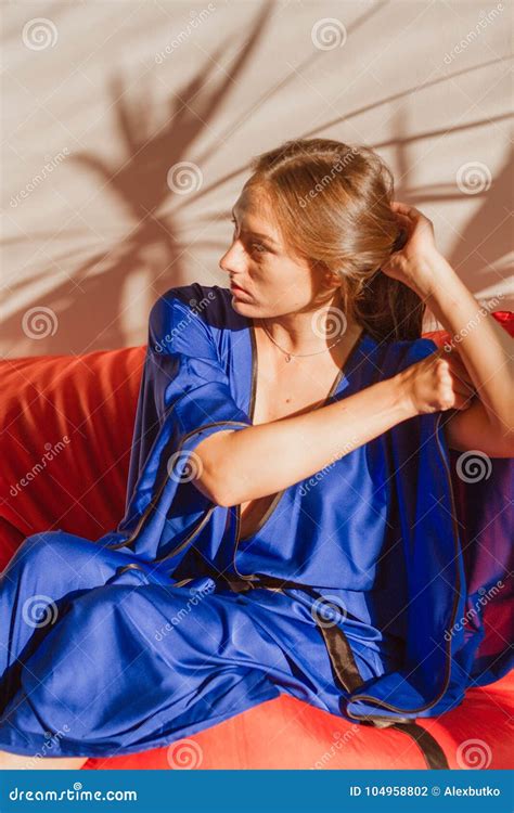 Beautiful Girl In Blue Silk Robe Resting In The Sunlight Stock Photo