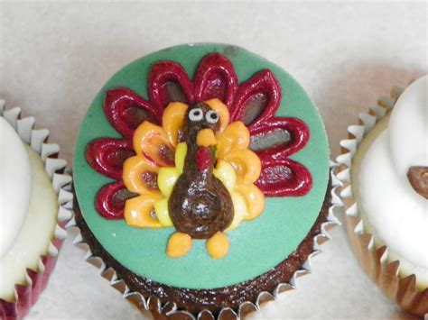 three cupcakes decorated to look like turkeys