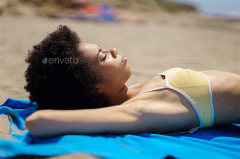 Relaxed Black Woman Lying Tanning On The Sand Of A Tropical Beach