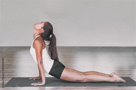 Asian Woman Stretching Lower Back With Yoga Cobra Pose On Exercise Mat