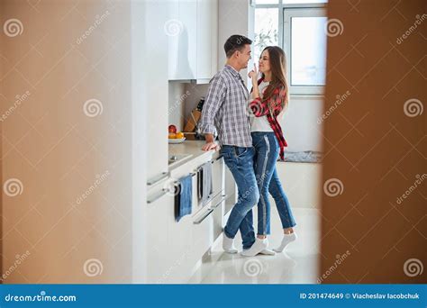 Mischievous Woman Teasing Her Husband In The Kitchen Stock Image