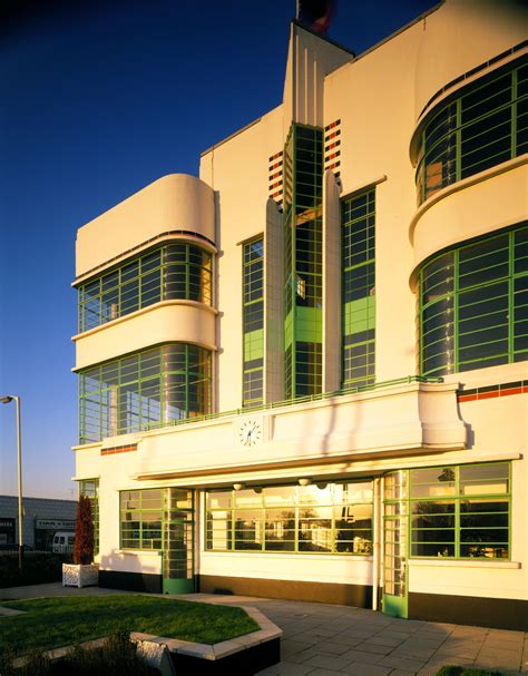 An Art Deco Building With Green Shutters On The Front And Side Windows
