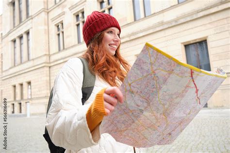 Redhead Girl Tourist Explores City Looks At Paper Map To Find Way For