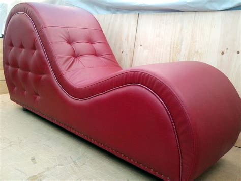 A Red Leather Chaise Lounge Chair Sitting On Top Of A Wooden Floor Next To A Wall