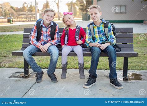 Three Young School Kids Sitting On A Bench Stock Image Image Of