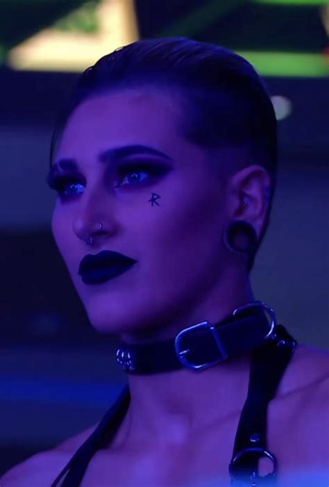 A Woman With Dark Makeup And Piercings On Her Face Wearing Black Choker
