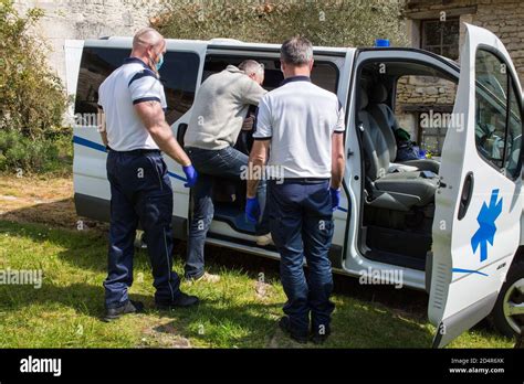 Ambulance drivers in front of the home of a patient with suspected