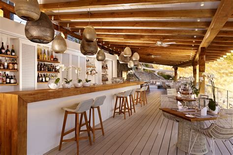 An Image Of A Beach Bar With Lots Of Bottles On The Counter And Stools