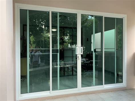 ประตูบานเลื่อนกระจกอลูมิเนียมสีอบขาวกระจกเขียวตัดแสงมือจับใหญ่ตัวล็อคคอม้าแทนประตูบานไม้ พีเอ