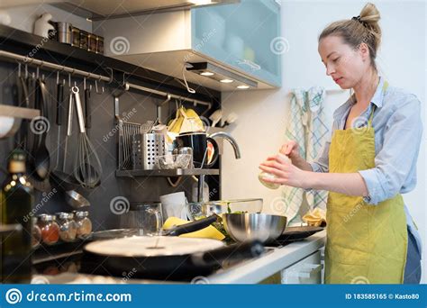 Stay At Home Housewife Woman Cooking In Kitchen Stir Frying Dish In A Saucepan Preparing Food