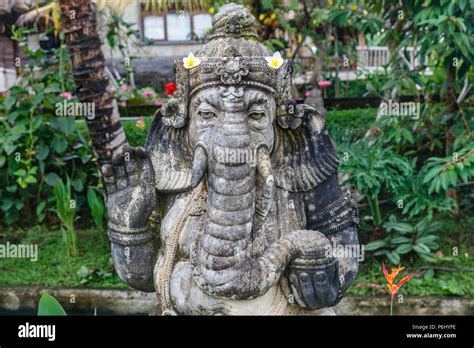 Stone Carved Hindu Ganesha Statue Decorated With Flowers Bali