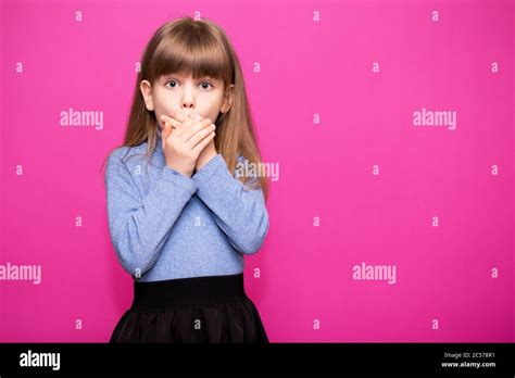 Cute Little Girl Covering Her Mouth Showing Intense Expression Of Fear