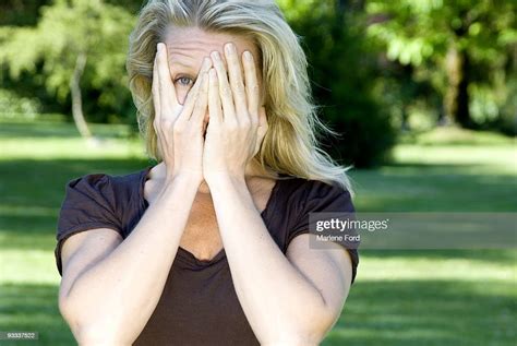 Woman With Hands Partly Covering Face Photo Getty Images