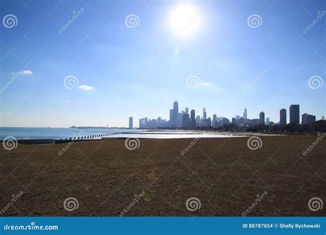 Sun Shining Brightly Over Chicago Skyline And A Frozen Lake Michigan