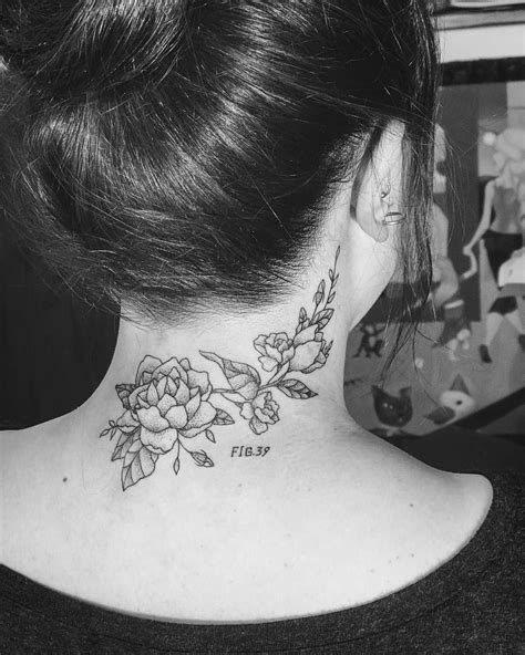 A Womans Neck Tattoo With Flowers On It