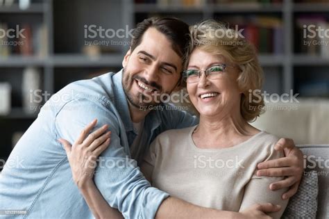 Smiling Adult Son And Senior Mother Visualize Looking In Distance Stock