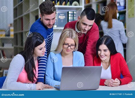 Group Of Students Working Together In Library With Teacher Stock Image