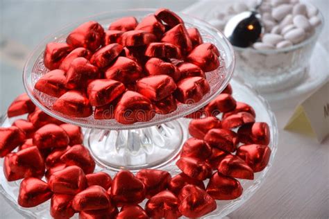 Close Up Of Red Heart Shaped Chocolates And Wedding Confetti Stock