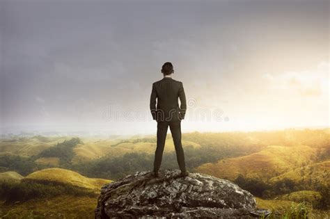 Business Man Standing On The Top Of The Mountain Looking