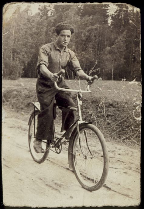 A Jewish Teenager Rides His Bicycle Along An Unpaved Road Between The