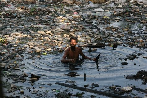 A Man Swims In A Highly Polluted Part Of The River Buriganga In Search