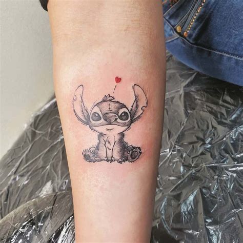 A Small Tattoo On The Leg Of A Person With A Red Heart In Her Hand
