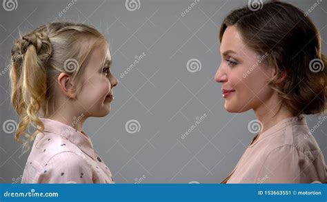 Smiling Mother And Daughter Looking At Each Other Growing Up