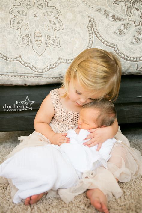 Big Sister Holding Newborn Baby Brother For Photo Session In Philadelphia
