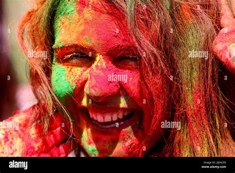 An Indian Young Woman Smiles With Her Face Smeared With Colors Ahead Of