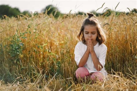 Little Girl Closed Her Eyes Praying In A Field Wheat Hands Folded In