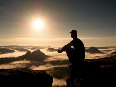 Moment Of Loneliness Man Sit On Rock And Watching Into Colorful Mist