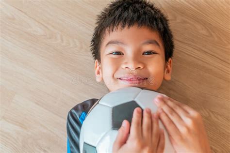 Happy Soccer Boy Lying On Floor Holding A Soccer Ball With Copy Space